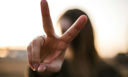 girl holding up a peace sign